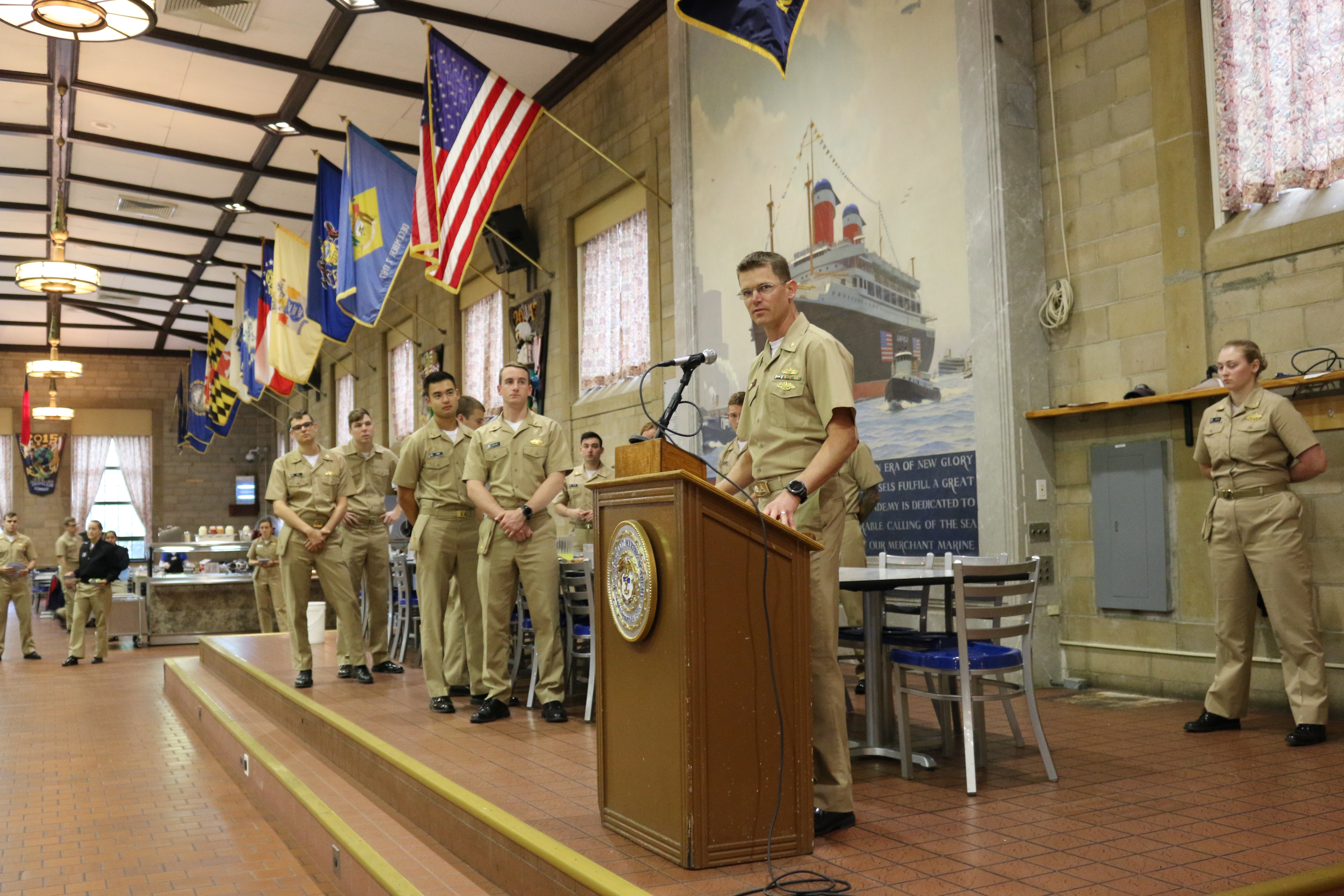 LCDR Cameron Ingram, '04 addresses the Regiment of Midshipmen during a lunchtime presentation