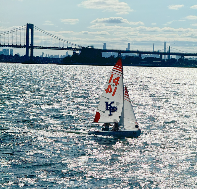 Sail boat sailing in front of New York skyline.