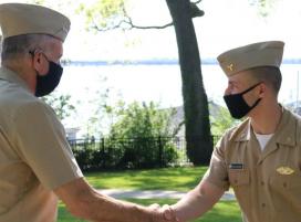 VADM Buono congratulates Midshipman George Houzouris, 4/c.