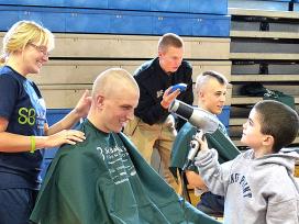 "Mighty Mikey" (right) helps Midshipman Tapper (left) during hair shaving fundraiser.