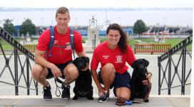 Midshipmen Gus Sawicki and Caitlin McCabe with the service dogs they are training, Tristian and Pal